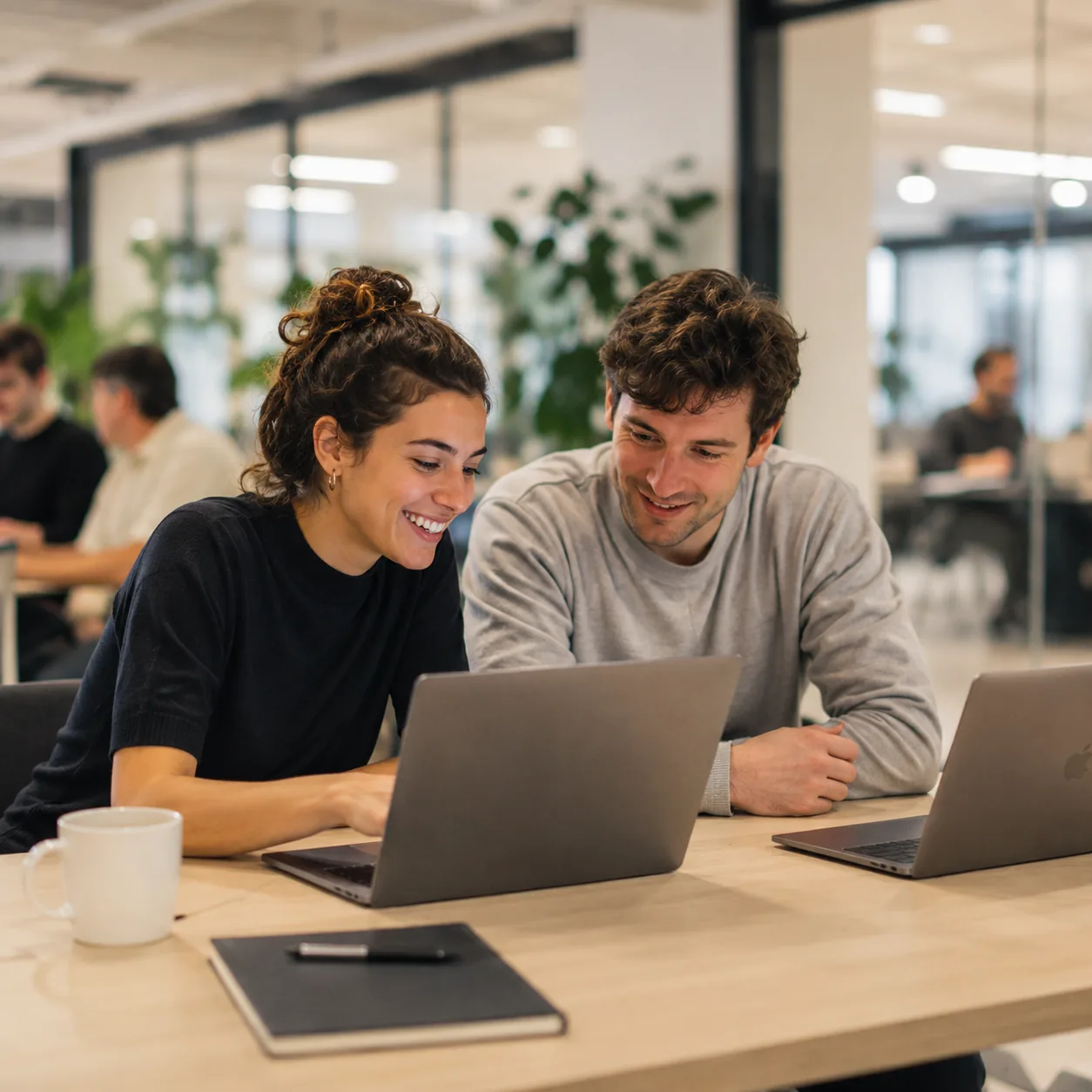 Deux apprenants travaillant côte à côte sur leurs ordinateurs en espace de coworking